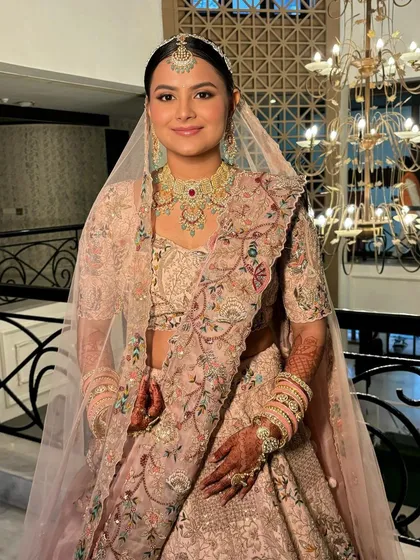 A full view of Rashi's look, complete with a sheer veil. The makeup enhances her features without overpowering the intricate outfit.