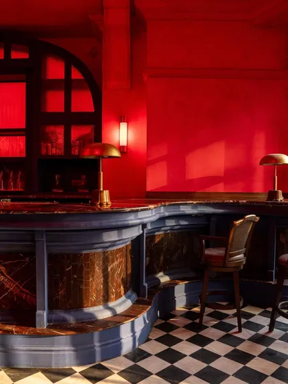 A detail of the bar, where the contrast of the blue base, marble top, and red surroundings creates a rich, jewel-toned palette.