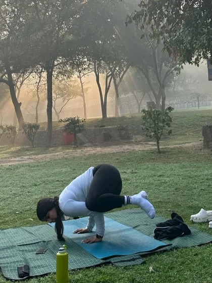 A moment of focus in Bakasana, or crow pose, during our outdoor session.