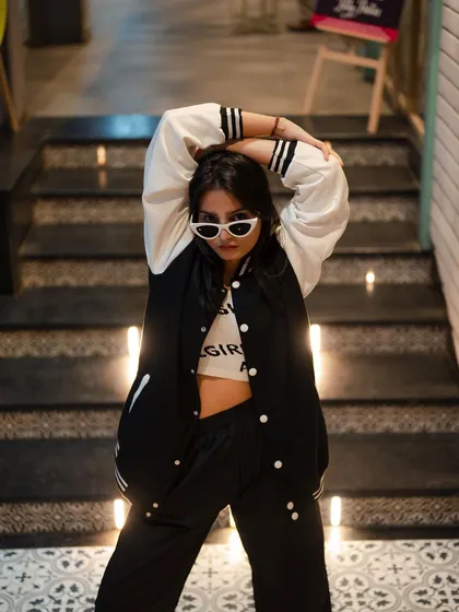 A dynamic pose on a staircase. The model's pose and the unique angle create a high-energy fashion shot that is full of attitude.