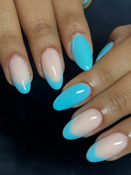A full view of the almond-shaped nails with a vibrant blue French tip design.