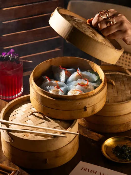 Dim sum and cocktails, a perfect pairing. This shot combines food and drinks to showcase a complete dining experience.