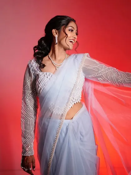 A fun, happy shot of the bride against a vibrant red background. Her smile is infectious, and her makeup looks flawless and radiant.