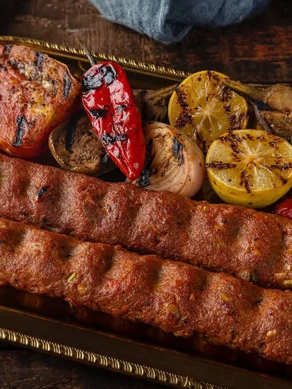 Mutton seekh kebabs with grilled vegetables, shot for Punjab Grill. The image captures the smoky, charred essence of tandoori cooking.