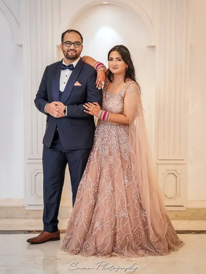 A classic portrait of the engaged couple, standing together and smiling for the camera.