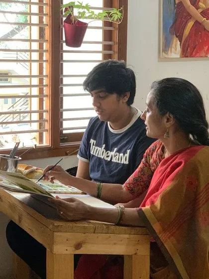 An instructor sits with a student at an easel, providing a live demonstration. This side-by-side teaching method is one of the most effective ways to learn and refine artistic techniques.