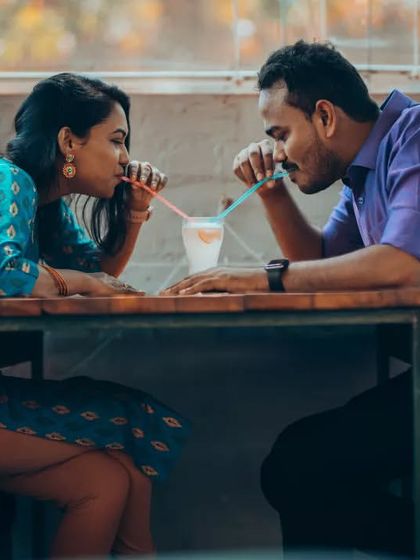 A fun and playful moment as a couple shares a drink at a cafe. These relaxed, lifestyle-type sessions are perfect for capturing your everyday love story.