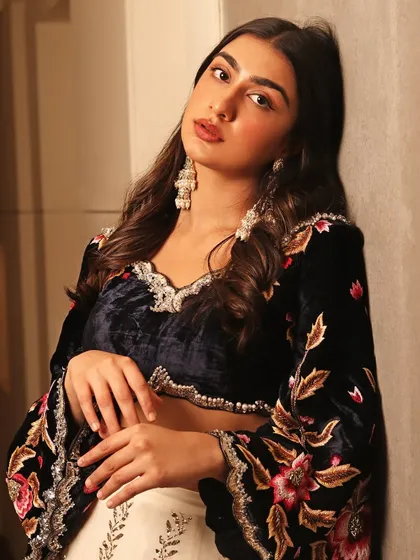 A softer angle of this modern festive look. The makeup highlights glowing skin and subtly defined lips, complementing the rich texture of the velvet blouse and the intricate embroidery.