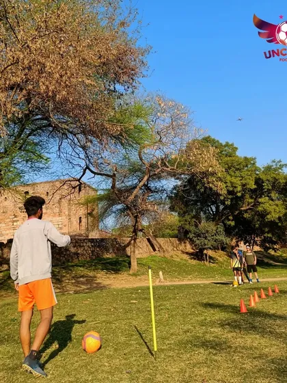 One of our coaches setting up a drill for the kids. We provide hands-on guidance and demonstrate techniques to ensure every player understands the fundamentals correctly.