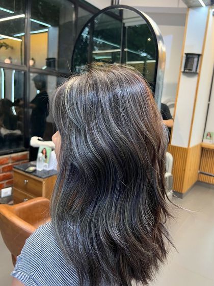 The same ash blonde babylights, this time with a fringe, showing how the color can complement a stylish cut.