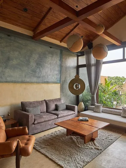 In the heart of Bangalore, we designed the Magnolia penthouse to be an urban oasis. This living space, with its natural timber roof and pigmented cement walls, opens up to a lush terrace, blurring the line between indoor comfort and outdoor serenity.