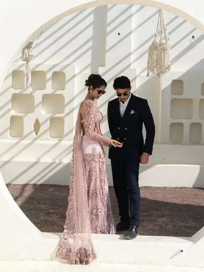 We love putting together a great couple's look. Here, a stunning pale pink embroidered lehenga is perfectly complemented by a sharp navy double-breasted suit. We help you create coordinated looks for shoots and events that are stylish, not cheesy.