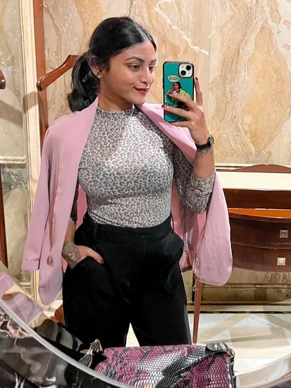 A close-up of my pink blazer look. Draping a blazer over your shoulders is a styling trick that adds an effortless layer of chic to any professional outfit.