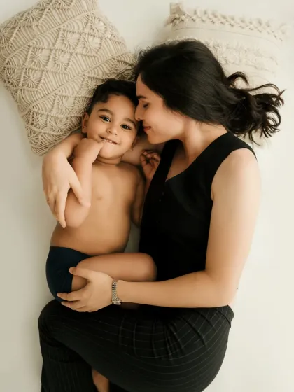 A mother and son lie down together, sharing a sweet look. This relaxed pose is perfect for a lifestyle family photoshoot.