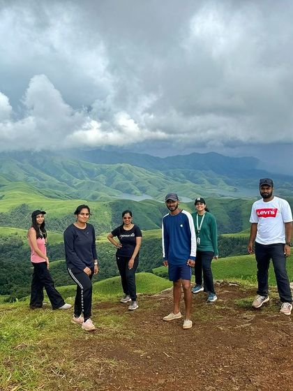 A group of trekkers posing on the Gangadikal trail with the stunning valley view.