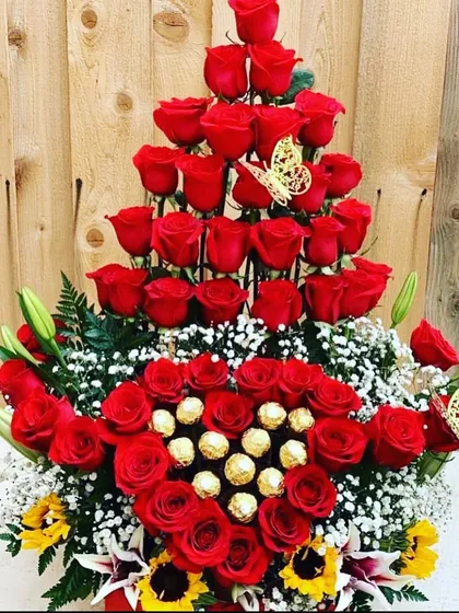 A grand, multi-tiered arrangement of red roses and Ferrero Rocher chocolates. The heart-shaped chocolate center and towering roses make this a truly spectacular declaration of love.