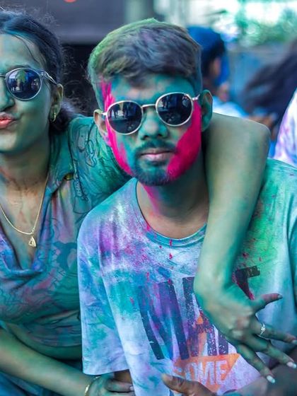 A couple enjoying the vibrant and playful atmosphere of the Holi party. It's all about letting loose and having fun.