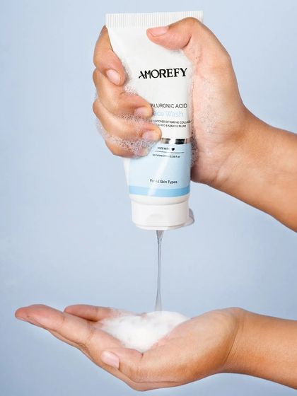 A lifestyle shot showing a hyaluronic acid cleanser being dispensed into a hand. This helps demonstrate the product's texture and usage in a relatable way.