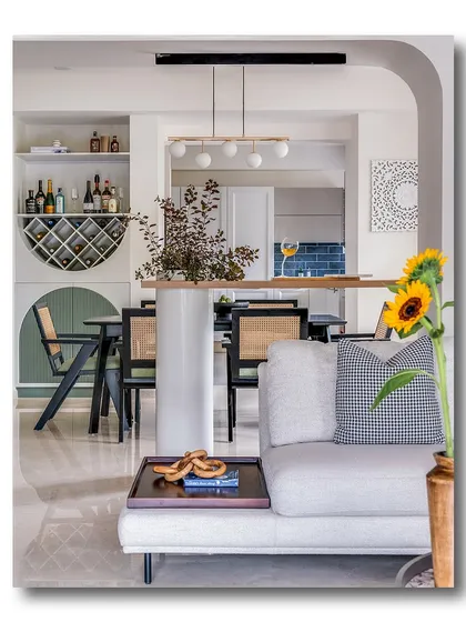 A view through an archway into a dining and bar area, with a sunflower adding a pop of color in the foreground. This shot highlights the home's layered design and the seamless flow between different functional zones.