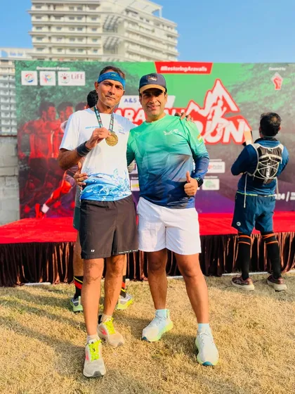 Posing with a participant and his finisher medal in front of the stage. I make it a point to connect with as many runners as possible.