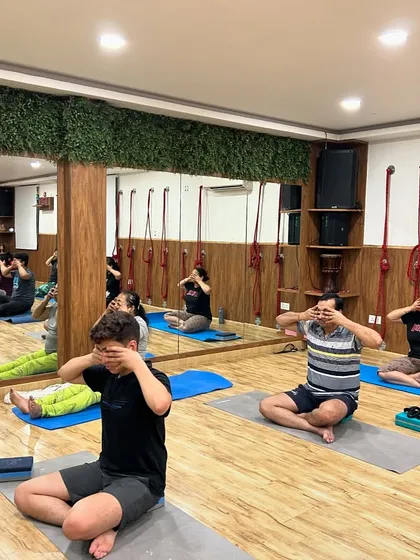 The reflection in the mirror shows the entire class engaged in Brahmari Pranayama. This practice is a wonderful tool for reducing anxiety and preparing the mind for meditation.
