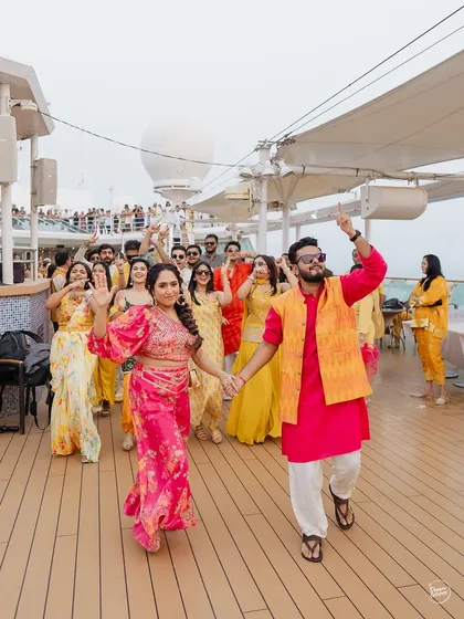 The bride and groom leading their crew in a dance on the deck of the Cordelia Cruise. A Haldi celebration on the Arabian Sea is a vibe of its own.