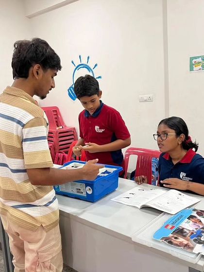 An instructor provides guidance to a team of students at Vidyashilp Academy, fostering a collaborative and supportive learning environment.