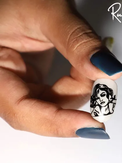 Holding the stamped portrait nail to show the fine details.