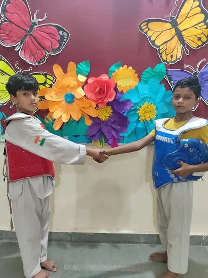 Sportsmanship is a key lesson in Taekwondo. Here, two opponents shake hands before their match, showing respect.