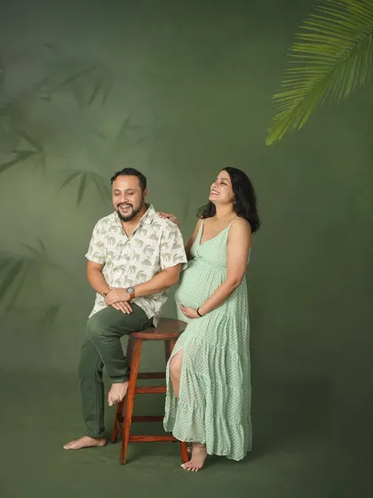 A moment of shared laughter and joy. This couple's relaxed and happy vibe was perfect for our green-themed studio setup, creating a natural and candid maternity portrait.