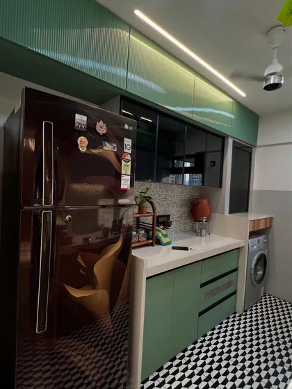 A practical corner of the kitchen, showing how appliances like the refrigerator and washing machine are neatly integrated into the design.