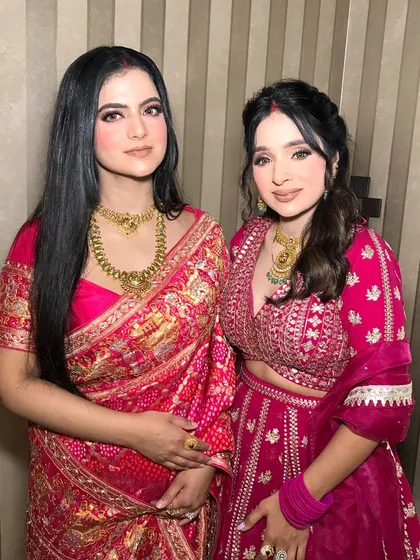 Two sisters-in-law, a 'nanad-bhabhi' duo, both looking gorgeous in pink and styled with traditional gold jewelry.