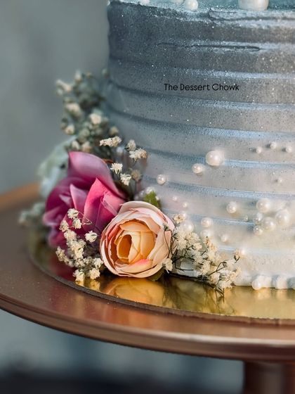 A side view of the silver anniversary cake, showing the textured frosting and how the flowers are placed to create a cascading effect.