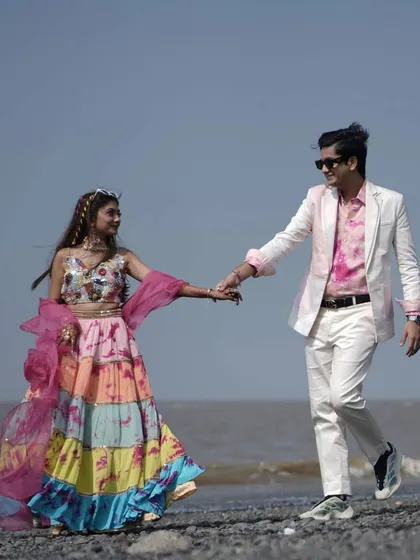 A romantic walk on the beach. The couple's colorful, tie-dye outfits were perfect for their fun and relaxed carnival theme.