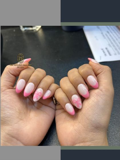 Pretty in pink. This set features a modern pink French tip, a delicate floral accent nail, and a cute 3D bow.