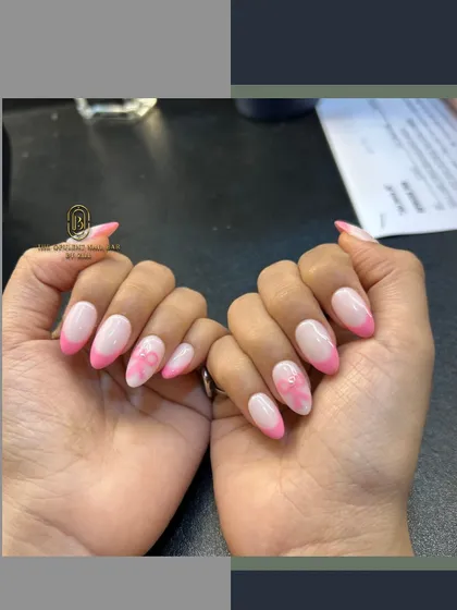 Pretty in pink. This set features a modern pink French tip, a delicate floral accent nail, and a cute 3D bow.