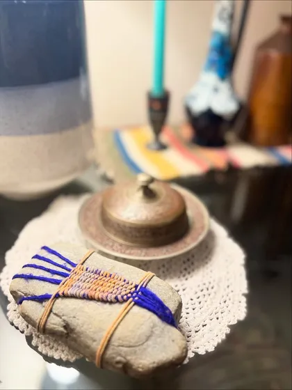 Weaving can take many forms, even wrapping a simple stone with yarn to create a small, personal sculpture. This piece, inspired by the Japanese art of pebble wrapping, shows how fiber art can be a meditative practice that finds beauty in natural objects.