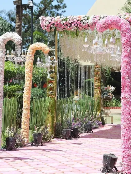 A whimsical and creative entrance pathway featuring candy cane-shaped floral arches. This unique design in pastel colors adds a playful and unforgettable touch to the wedding decor.