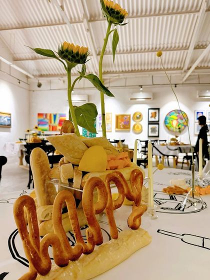 The word "Happy" sculpted from bread adds a joyful and whimsical touch to this artistic tablescape. It demonstrates our ability to think outside the box and create truly bespoke decor elements.