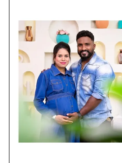 A happy and relaxed couple's portrait. Their matching denim outfits create a casual, coordinated look. The blurred foreground adds an artistic touch, drawing the viewer's eye directly to their joyful expressions.