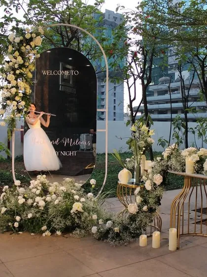 The welcome entrance to Miloni and Yash's 'White Wonderland' reception. A mirrored sign, framed by an arch of white roses and baby's breath, set a tone of pure elegance and enchantment for the evening.