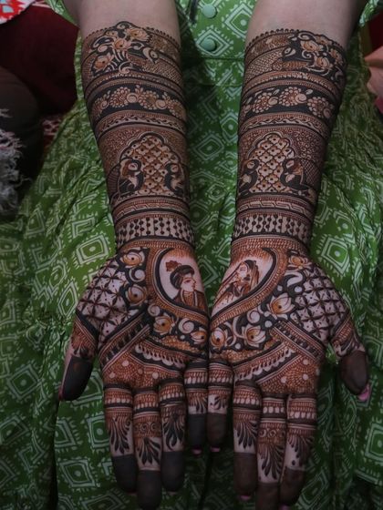 A beautiful example of combining couple portraits with floral and geometric patterns. The heart-shaped frame around the figures adds a romantic touch to this intricate bridal design.