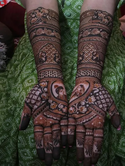 A beautiful example of combining couple portraits with floral and geometric patterns. The heart-shaped frame around the figures adds a romantic touch to this intricate bridal design.