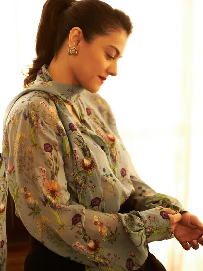 Kajol in a vintage-inspired floral blouse with a pussy-bow tie, a look that is both romantic and sophisticated.