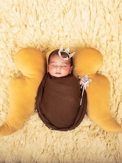 Your little angel. This newborn portrait uses soft angel wings, a tiny crown, and a magic wand prop to create a sweet and whimsical image.