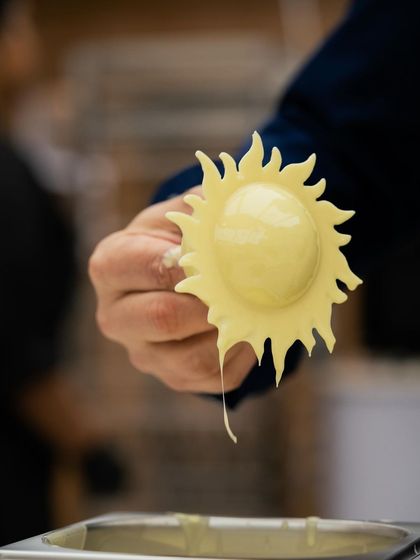A sun-shaped chocolate garnish, showcasing creative mold work and the playful side of pastry.