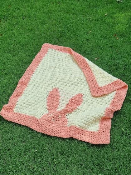 Another view of the bunny blanket, showing its lovely drape. It's lightweight but warm, made from soft cotton yarn.