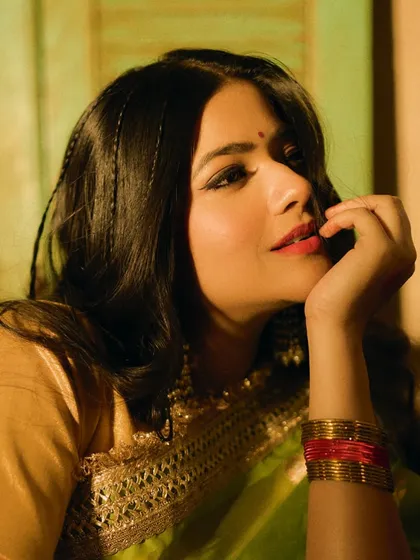 A thoughtful portrait of Sakshi Gopal from the 'Prem Patra' series. The makeup is soft and nostalgic, with thin braids and traditional bangles adding to the vintage feel.