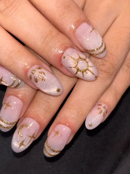 A celestial-themed design on a shimmery cat eye base, with intricate gold paintings of suns, moons, and stars.