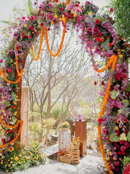 A beautiful floral archway bursting with color, welcoming guests to the 'Rajasthani Folklore' Mehendi.